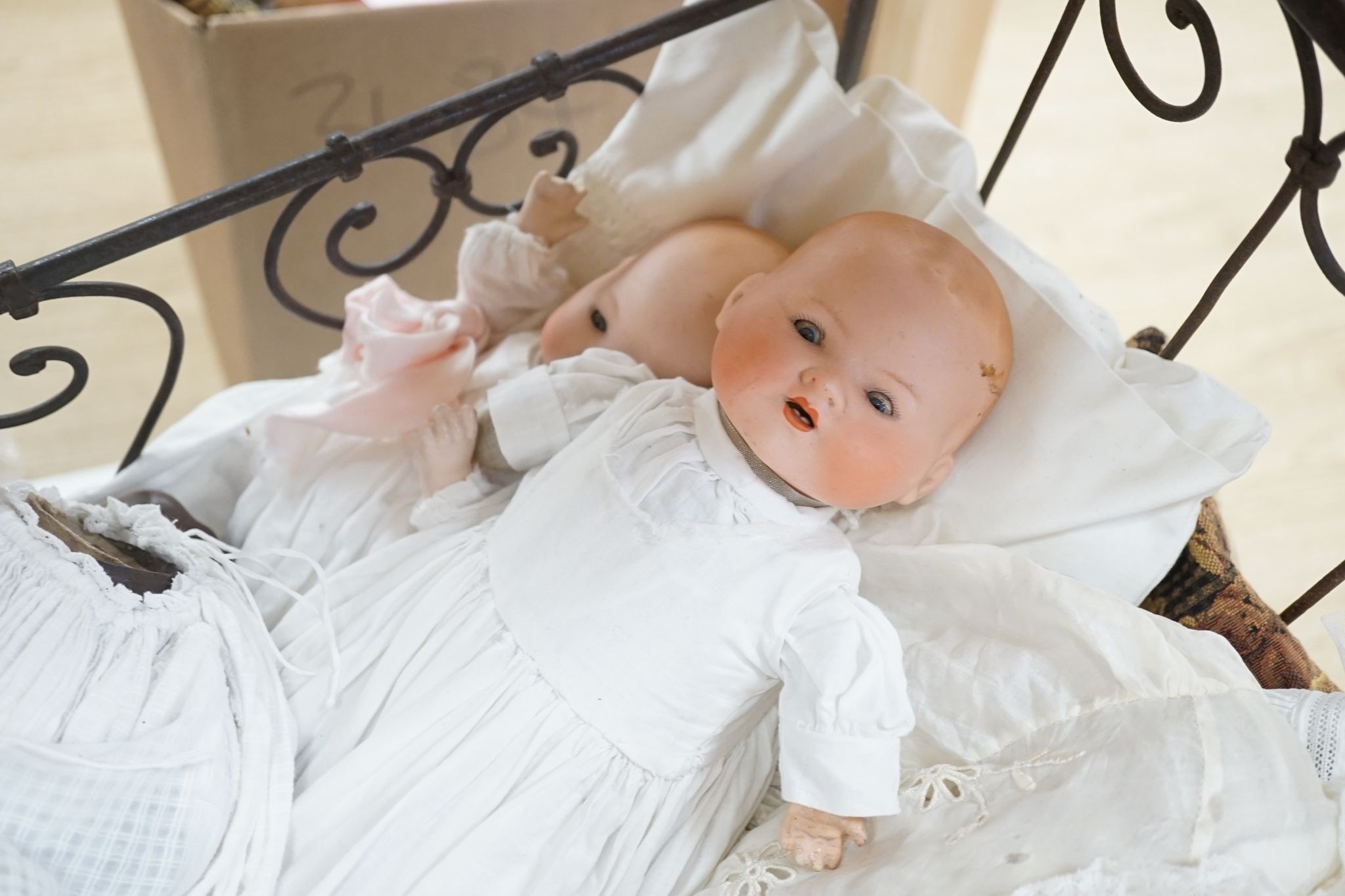 3 Armand Marseille bisque head dolls with sleeping eyes and 4 others in a wrought iron dolls crib 80cm